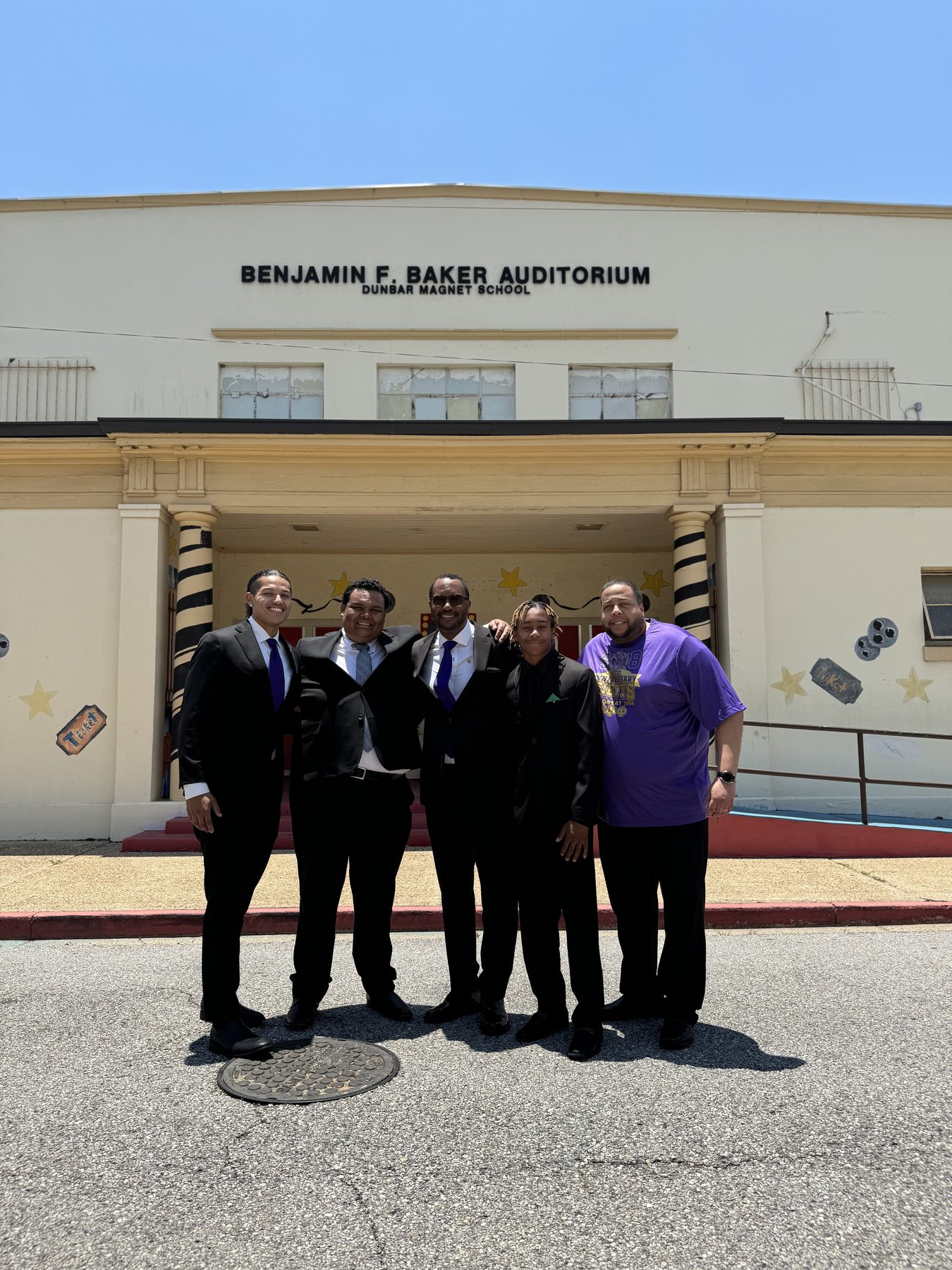 Dr. Vic Baker with great-grandsons of Dr. Benjamin F. Baker in front of the Benjamin F. Baker Auditorium at Dunbar Magnet School